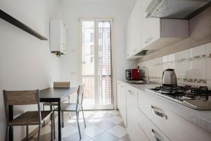 a white kitchen with a table and a stove top oven at Cavour 96 Apartment in Florence