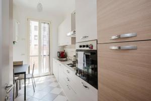 a kitchen with white cabinets and a stove top oven at Cavour 96 Apartment in Florence