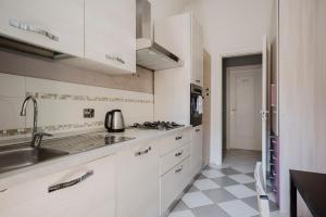 a white kitchen with a sink and a stove at Cavour 96 Apartment in Florence +26 photos