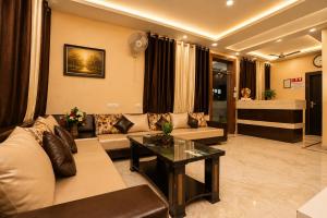 a living room with a couch and a table at Hotel Aaradhya Residency in Agra