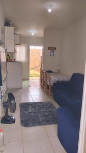 a living room with a blue couch and a kitchen at Casa Aconchegante S8km do parque do peão in Barretos