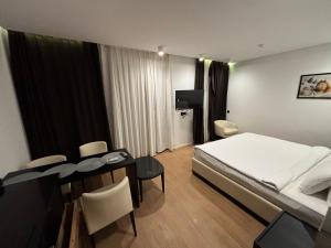 a hotel room with a bed and a table and chairs at SeaBreeze White Villa 42 in Nardaran
