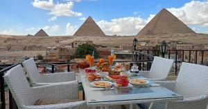a table with food on it with pyramids in the background at Golden Pyramids Inn in Cairo