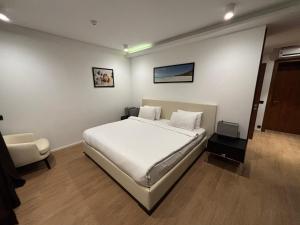 a bedroom with a white bed and a chair at SeaBreeze White Villa 42 in Nardaran