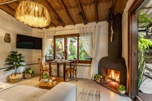 a living room with a fireplace and a table at Chalés Magia do Campeche in Florianópolis