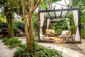 a garden with a pergola in the middle of a yard at Chalés Magia do Campeche in Florianópolis