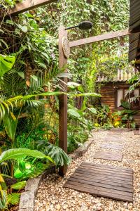 a garden with a wooden walkway and a fence at Chalés Magia do Campeche in Florianópolis +17 photos