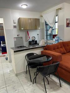 a living room with a couch and a table at cozy 1bedroom mombasa bamburi near the beach with hot shower, Netflix, Secured parking 07&07 for 95 then 61to18 in Mombasa