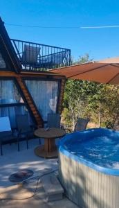 a hot tub on a patio with a table and an umbrella at Villa Leos in Ferizaj