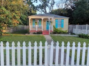 a yellow and blue house with a white fence at The Lemon Zest Cottage Paws Welcome in Pensacola