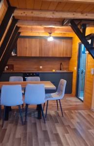 a dining room with a wooden table and chairs at Villa Leos in Ferizaj