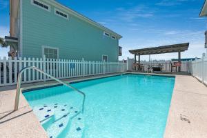 a swimming pool in front of a house at M & S Turtle Cove in Port Aransas