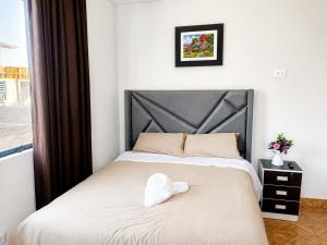 a bedroom with a bed with a hat on it at Villa Garden in Ica