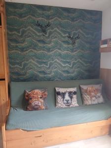 three stuffed animals sitting on a bed with pillows at Studio en station de ski familiale, vue sur les montagnes in La Morte