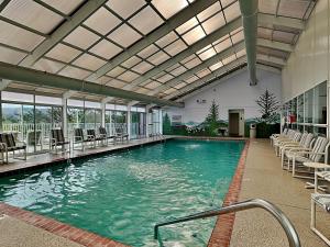 a large swimming pool with chairs in a building at Rock-a-While Whispering Pines 214 in Pigeon Forge