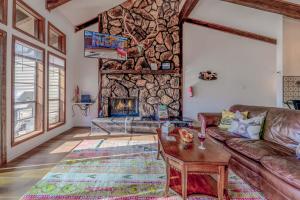 a living room with a couch and a stone wall at Hold Your Horses in Ruidoso