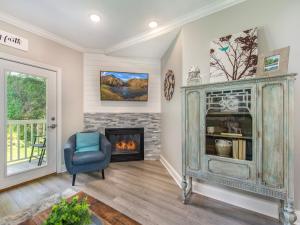 a living room with a fireplace and a chair at Lazy Bears Den 2103 in Pigeon Forge