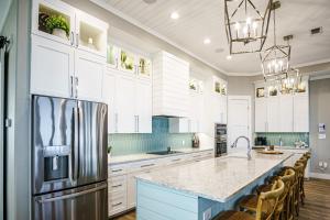 a kitchen with white cabinets and a stainless steel refrigerator at The Sanctuary in Padre Island