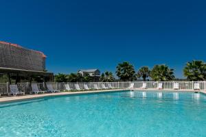 a large swimming pool with lounge chairs and trees at On the Half Shell in Port Aransas