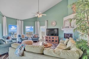 a living room with couches and a tv at Crandalls Cottage in Port Aransas