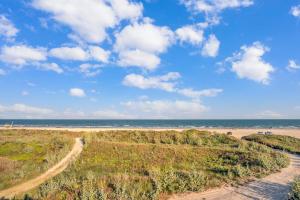 a dirt road leading to a beach with the ocean at Crandalls Cottage in Port Aransas