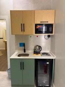 a small kitchen with a sink and a microwave at لين سويت in Khamis Mushayt +69 photos