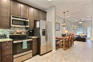 a kitchen with stainless steel appliances and a dining room at Surfin Seahorse in Port Aransas