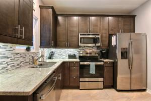 a kitchen with wooden cabinets and stainless steel appliances at Surfin Seahorse in Port Aransas +26 photos
