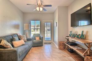 a living room with a couch and a flat screen tv at Family Tides Beach House in Port Aransas