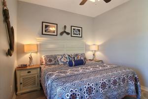 a bedroom with a bed and two lamps and two pictures on the wall at Family Tides Beach House in Port Aransas