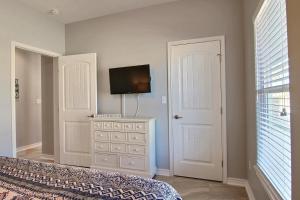 a bedroom with a bed and a tv on a dresser at Family Tides Beach House in Port Aransas +20 photos