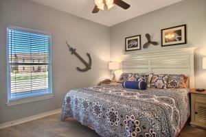 a bedroom with a bed and a fan and a window at Family Tides Beach House in Port Aransas