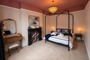 a bedroom with a four poster bed and a mirror at Fox House Llandudno in Llandudno