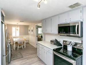 a kitchen with white cabinets and a stove top oven at Cape Cod Cottage in Port Aransas