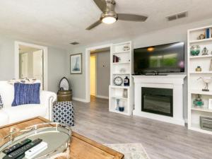 a living room with a white couch and a tv at Cape Cod Cottage in Port Aransas