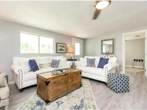 a living room with two white couches and a coffee table at Cape Cod Cottage in Port Aransas