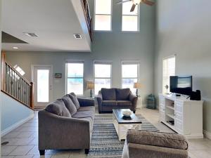 a living room with two couches and a tv at Sandy Starfish in Port Aransas