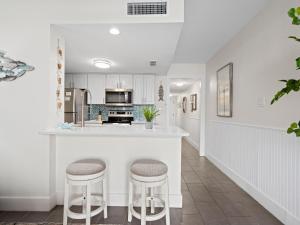 a kitchen with white cabinets and bar stools at Laguna Reef #311 - Heavenly Hill in Rockport