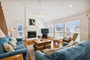 a living room with blue couches and a tv at Pelican Path in Galveston