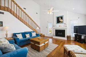 a living room with a blue couch and a tv at Pelican Path in Galveston