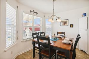 a dining room with a wooden table and chairs at Pelican Path in Galveston