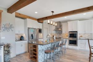 a kitchen with white cabinets and a island with bar stools at Itll Do in Padre Island +31 photos