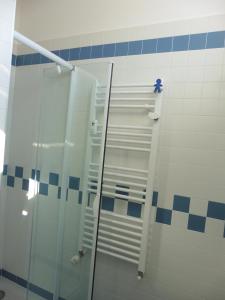 un bagno con doccia in vetro e piastrelle bianche e blu di Ichnussa a Udine