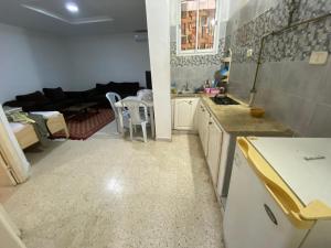 a kitchen and a living room with a couch at Raies in Akouda