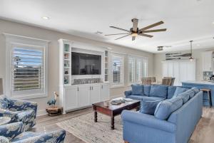 a living room with blue furniture and a ceiling fan at Downtime in Padre Island