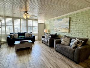 a living room with two couches and a brick wall at Pearl Marlin in Port Aransas