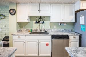 a kitchen with white cabinets and a sink at Pearl Marlin in Port Aransas