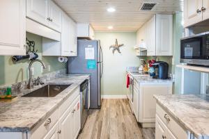 a kitchen with white cabinets and a blue refrigerator at Pearl Marlin in Port Aransas +16 photos