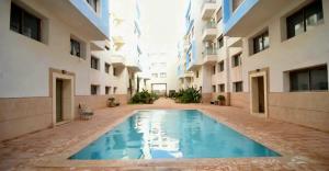 a swimming pool in the middle of a building at sunny amazigh apt avev piscine pool steps from beach 2balcony 2smartTV pool in Essaouira