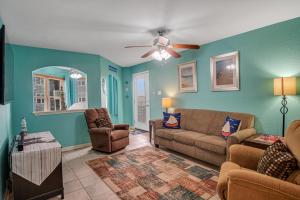 a living room with a couch and chairs and a ceiling fan at Pawsitively Paradise in Mustang Beach